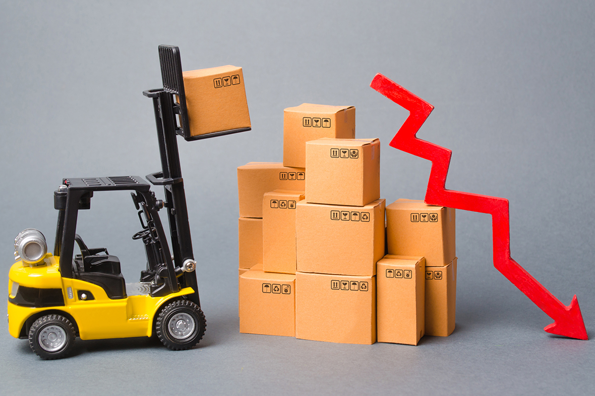 Minature forklift lifting carboard boxes with red graph arrow pointing downwards